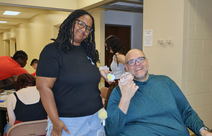 Pebbles and Pins#6_web H-F Senior Nina Anderson stands beside Design Thinking and Collaborative Arts teacher J.R. Willard-Rose with a painted self-portrait of Mr. Rose. (Nuha Abdessalam/H-F Chronicle)