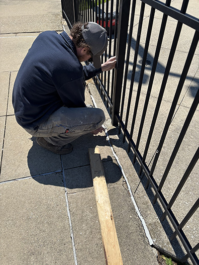 Homewood-Flossmoor Park District employee Kenny Nye works to make certain the fencing is secure around the Lions Club Pool's baby pool. Last minute repairs are being made before the pool's opening on May 30. (Marilyn Thomas/H-F Chronicle)