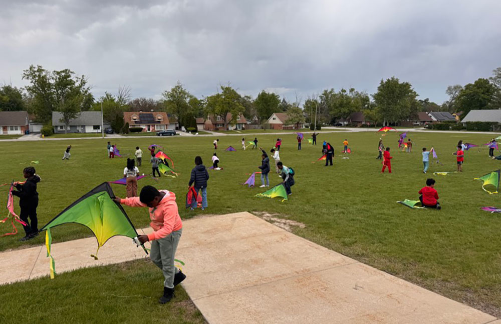 Third graders at Serena Hills School in Flossmoor spread out over the lawn to work on getting their kites in the air during a science lesson on May 7. (Provided photo)