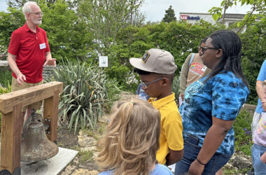 Volunteer Mark Leschuck shares the history of the old school bell in the garden of the Homewood Historical Society. (Marilyn Thomas/H-F Chronicle)