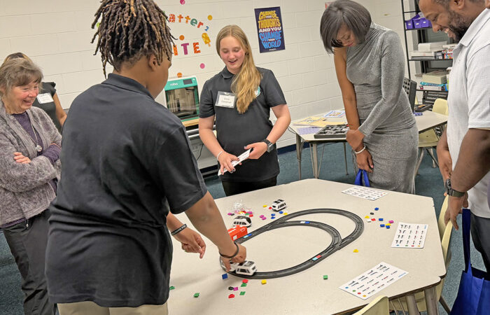 You Matter 2 fundraiser -Ulanowski7_web You Matter 2 students Zavian Fowler, second from left, and Cora Donohue, third from left, show community members how to operate robotic trains in the STEM room. (Nick Ulanowski / H-F Chronicle)