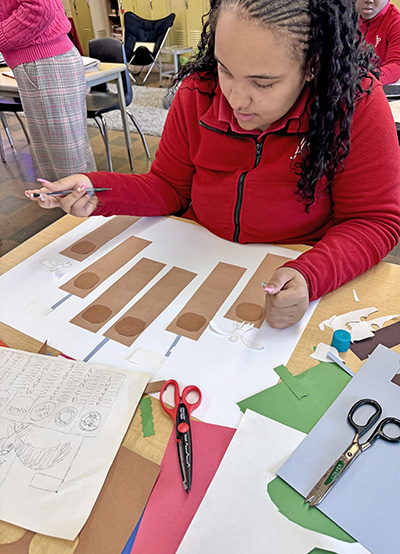 IJP 8th grader Ariel Plovanic of Park Forest works on her poster project, a rendering of her vision for the Flossmoor Veterans’ Memorial Project. (Karen Torme Olson)