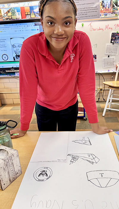IJP 8th grader IJP 8th grader Jordan Taylor of Olympia Fields with her poster project featuring the U.S. Navy. (Karen Torme Olson)