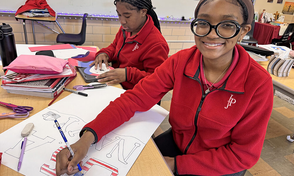 IJP 8th graders work on their poster projects for the FVM Time Machine lessons. Payton Thomas of Lansing (left) chose the U.S. Coast Guard as her subject while McKenzie Frison of Matteson crafts her poster on the U.S. Navy. (Karen Torme Olson)