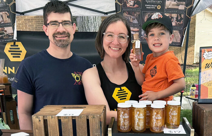 Art & Garden -Ulanowski11_web Art & Garden Fair vendor S&P Apiaries co-owner Hannah Stroh, center, with her husband, Peter Stroh, left, and her son, Ollie Stroh, right, sell local and specialty honeys. (Nick Ulanowski / H-F Chronicle)