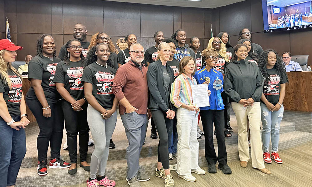 Flossmoor Mayor Michelle Nelson, center, holds a proclamation declaring June 3 as Global Running Day in the village. She is surrounded by members of the Homewood-Flossmoor High School state champion girls track team and by representatives of the Hidden Gem Half Marathon. (Jon Bannister/H-F Chronicle)
