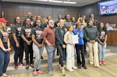 Flossmoor Mayor Michelle Nelson, center, holds a proclamation declaring June 3 as Global Running Day in the village. She is surrounded by members of the Homewood-Flossmoor High School state champion girls track team and by representatives of the Hidden Gem Half Marathon. (Jon Bannister/H-F Chronicle)