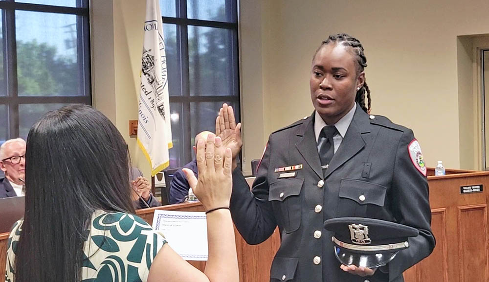 New Homewood police officer Lorielle Brown takes the oath of office, administered by Village Clerk Nakita Flores, during the May 26 Board of Trustees meeting. (Eric Crump/H-F Chronicle)