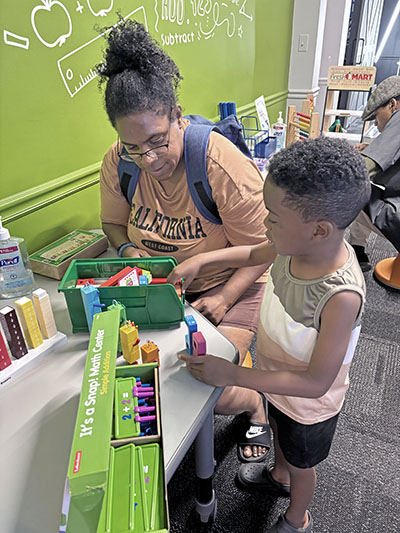 Mom Candace McDonald helps her son, Kingston, with a counting exercise at the Homewood Science Center. (Marilyn Thomas/H-F Chronicle)