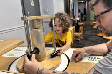 Rowan Lyday and his dad, Erik, try to attract magnets that are just one of the exhibits at the Homewood Science Center. (Marilyn Thomas/H-F Chronicle)