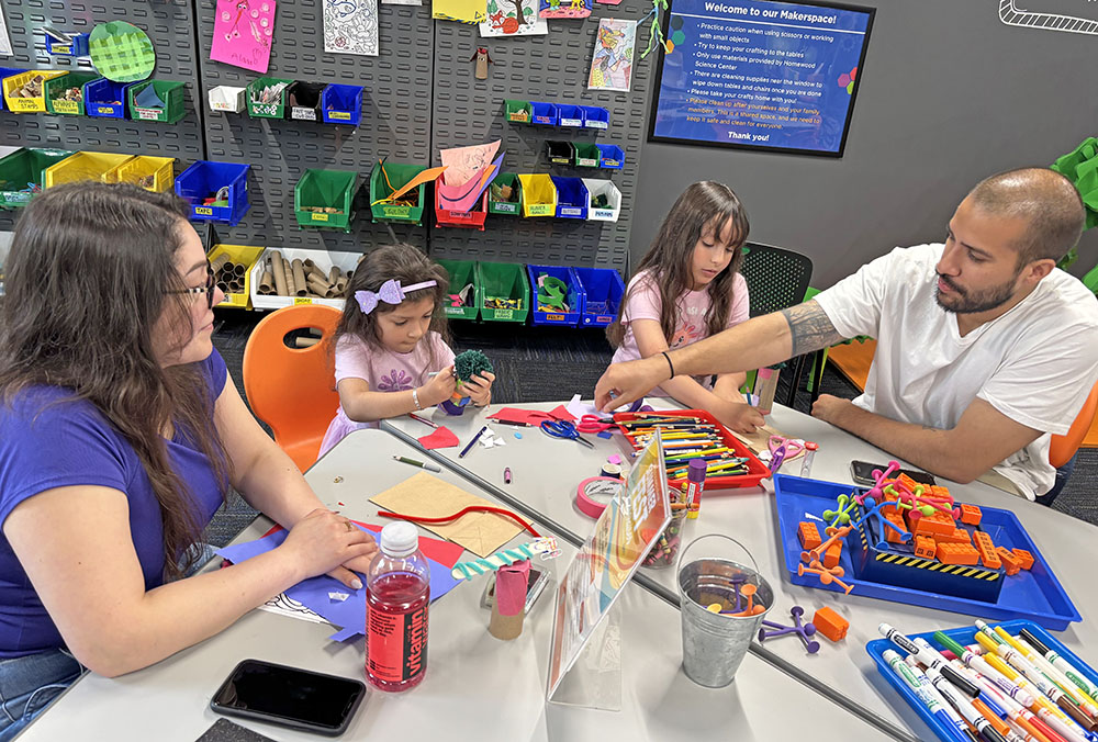 The Valles family, from left, mom Jackie, daughters Violet, 5, and Brylee, 9, with dad Jeffie, work in the STEAM Studio June 6. They were visiting the Homewood Science Center from Lynwood. (Marilyn Thomas/H-F Chronicle)