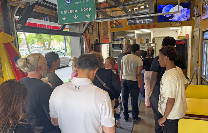 Community members line up to receive free hot dogs and chips at the grand opening of Hibbing’s Hot Dogs on June 1. (Nick Ulanowski / H-F Chronicle)