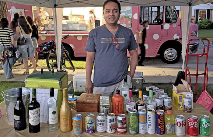 Family Wine and Liquors and Flossmoor Wine and Liquors owner Ronak Patel serves drinks to Pride Fest guests in Flossmoor Park. (Nick Ulanowski / H-F Chronicle)