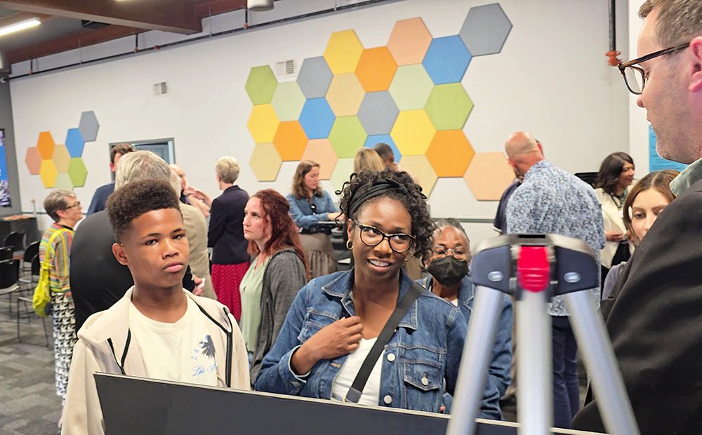 From left, Keylen Chatman and Michele Hogan talk with Mike Doyle of Holladay Properties about the company's proposed transit-oriented development projects in downtown Homewood at an open house June 16. (Eric Crump/H-F Chronicle)