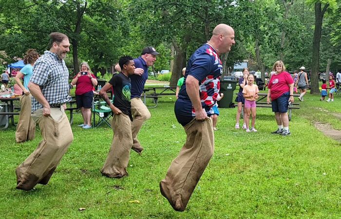Adults take a turn at the one-legged race during the Izaak Walton community picnic on July 4. (Eric Crump/H-F Chronicle)