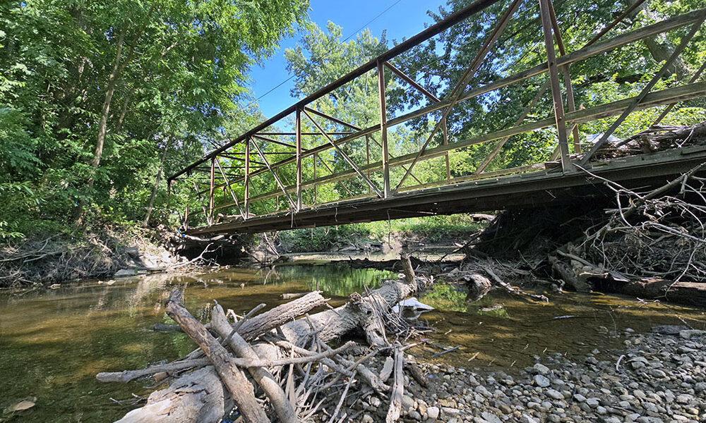 Dartmouth Pedestrian Bridge spans the now placid Butterfield Creek. Storms in June and July, however, produced flooding that pummeled the bridge, damaging its deck. (Eric Crump/H-F Chronicle)