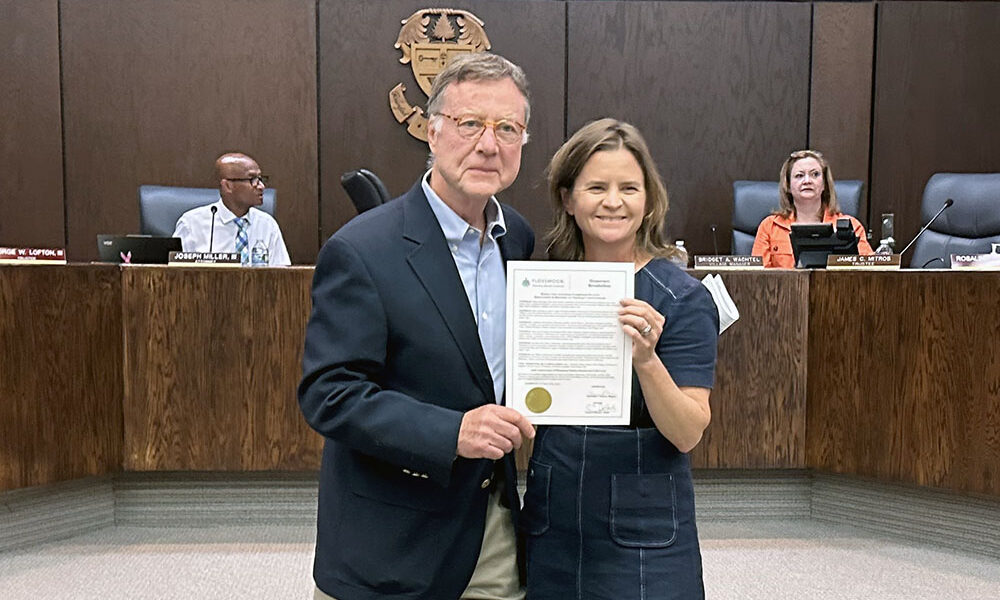Flossmoor Station Restaurant & Brewery co-owner Dean Armstrong, left, accepts a resolution from Mayor Michelle Nelson honoring the business for 30 years of service to the community. (Jon Bannister/H-F Chronicle)