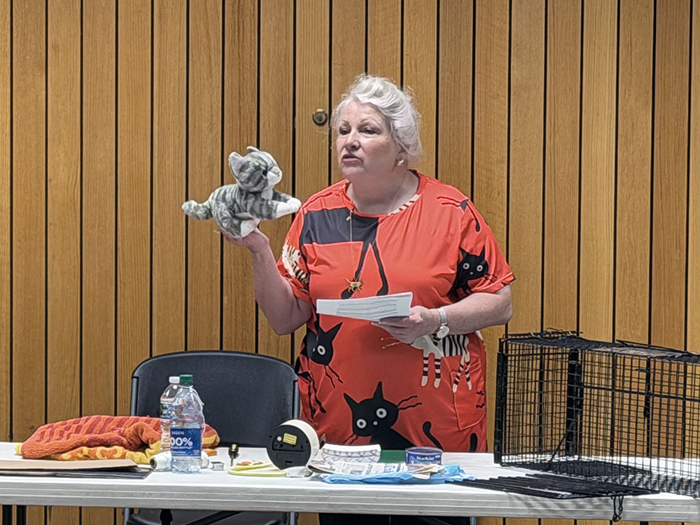 Pamela Caddick uses a stuffed cat to demonstrate safe handling techniques during Triple R Pets' trap-neuter-return workshop Saturday, July 18. (Nuha Abdessalam/H-F Chronicle)