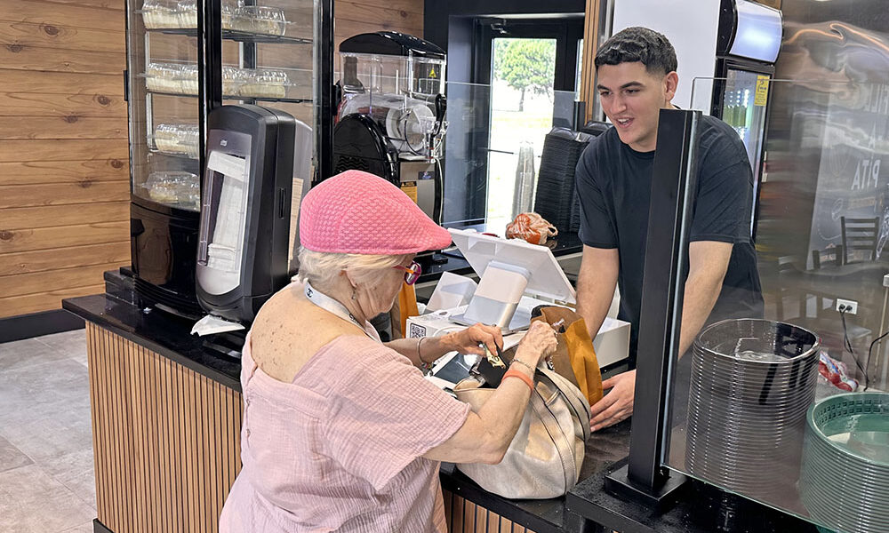 Fil-a-Pita owner Soltan Frehat hands a free pita to a customer during the restaurant's opening day Friday, July 17. (Jon Bannister/H-F Chronicle)