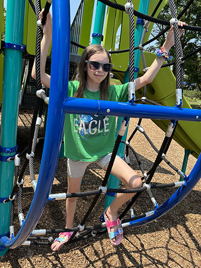 Raelyn Stratton, 10, started up the climbing apparatus in the reopened Irwin Park playground on July 15. (Marilyn Thomas/H-F Chronicle)