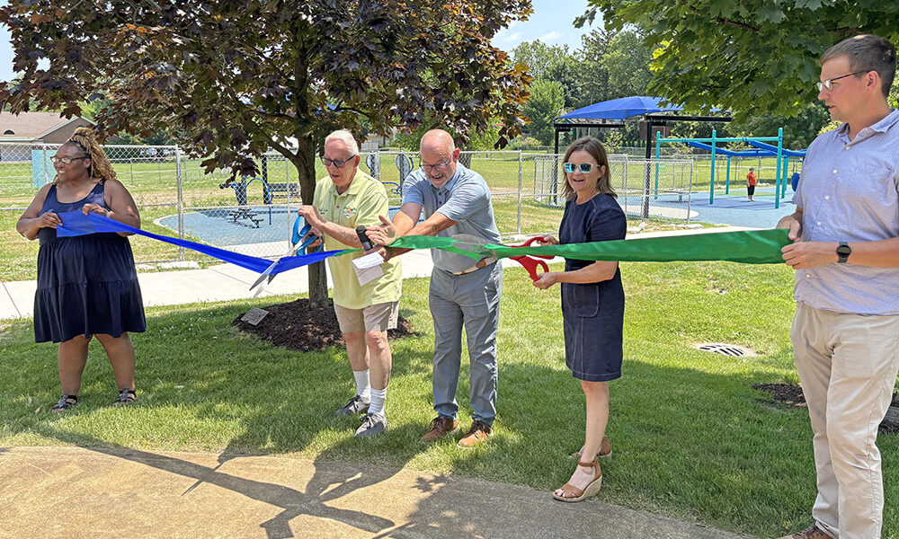 Ready to cut the ribbon to open the Irwin Park playground are Homewood Mayor Rich Hofeld, Homewood-Flossmoor Park District President Brent Bachus, center, and Flossmoor Mayor Michelle Nelson. They are joined by park district staff members Oralethea Davenport, left, and Zak Kerby, right. (Marilyn Thomas/H-F Chronicle)
