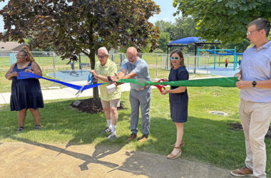 Ready to cut the ribbon to open the Irwin Park playground are Homewood Mayor Rich Hofeld, Homewood-Flossmoor Park District President Brent Bachus, center, and Flossmoor Mayor Michelle Nelson. They are joined by park district staff members Oralethea Davenport, left, and Zak Kerby, right. (Marilyn Thomas/H-F Chronicle)