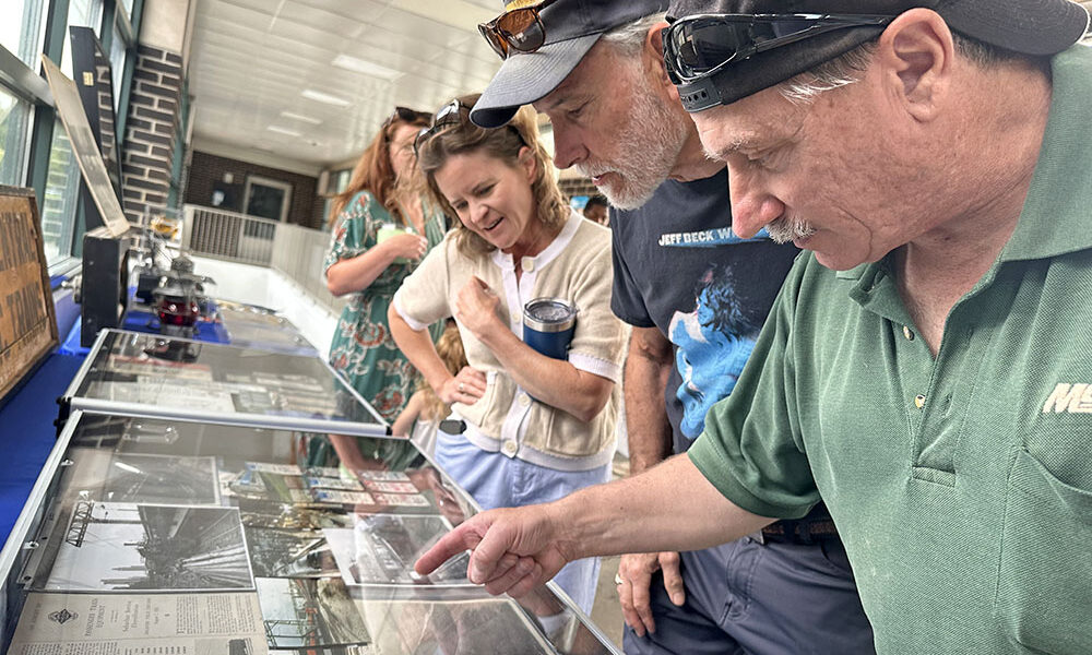 Joe Flens, right, shows Flossmooor Mayor Michelle Nelson, second from right, his collection of electric line memorabilia from his career working for what is now Metra. (Jon Bannister/H-F Chronicle)