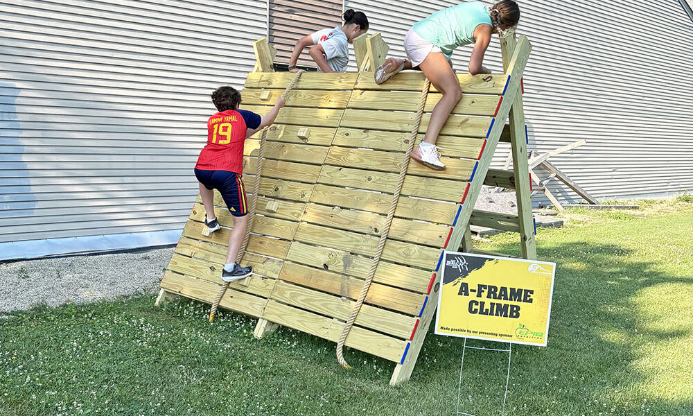 The Beast obstacle course has these three runners climbing over the A-Frame. (Marilyn Thomas/H-F Chronicle)