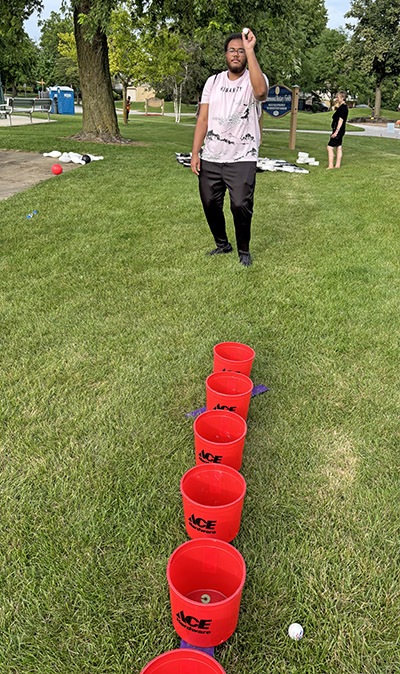 Elias Nelson of Homewood takes aim at the bucket at the activities portion of the picnic. (Marilyn Thomas/H-F Chronicle)
